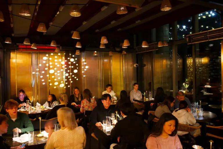 Couple enjoying a romantic dinner at Ayza Wine & Chocolate Bar in Midtown Manhattan, sharing gourmet food and wine in the cozy, candlelit ambiance of the restaurant.